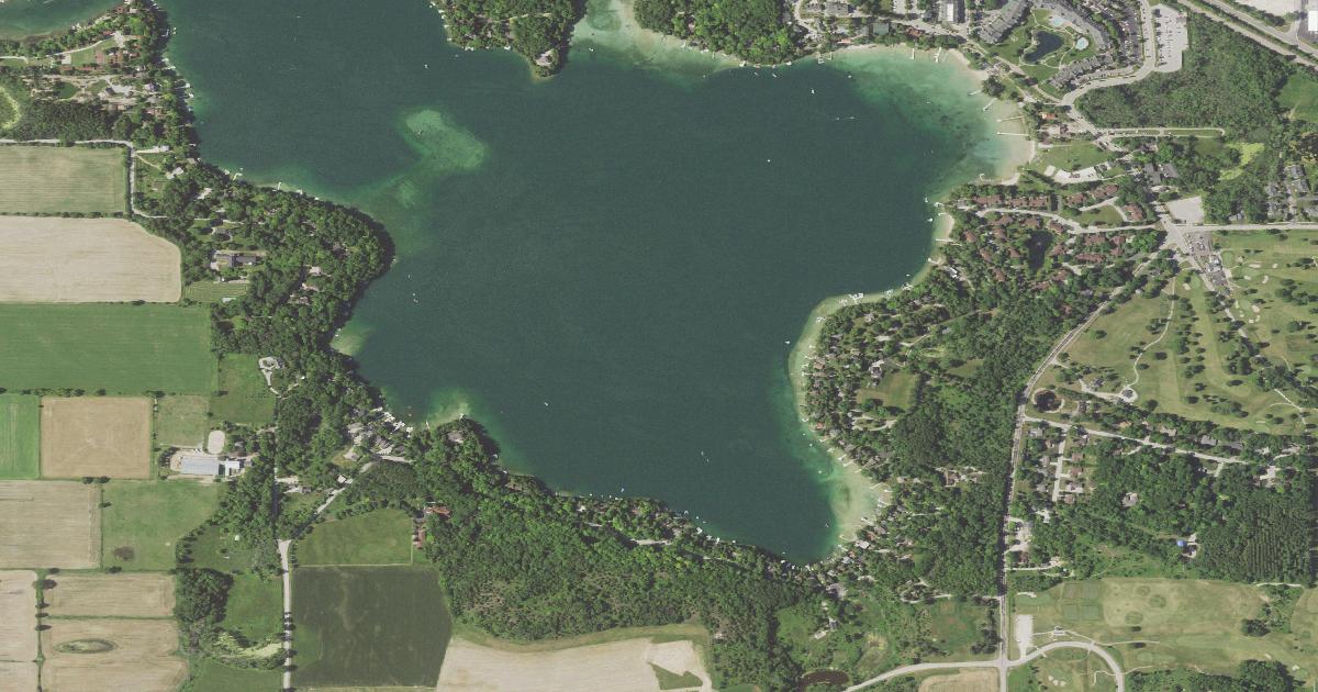 Aerial view of Elkhart Lake, a small round kettle lake with the resort village along its north and east shore