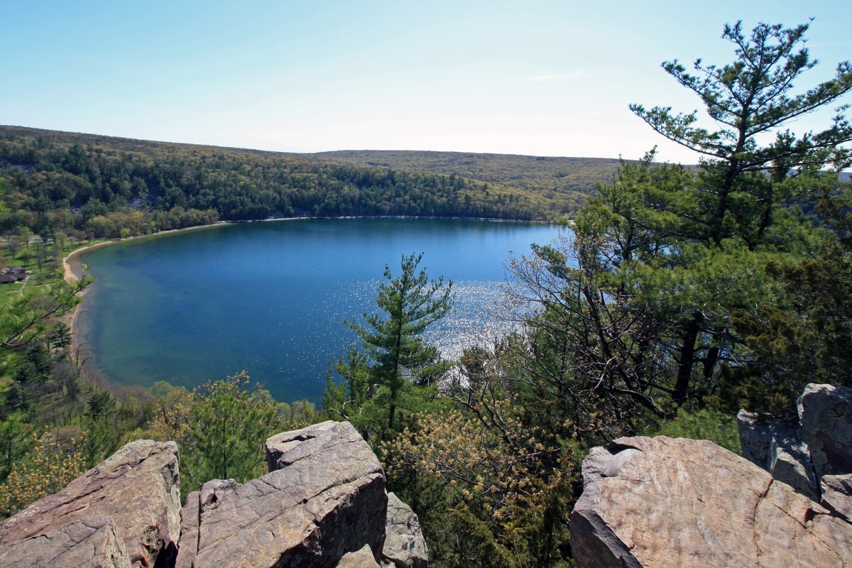 Devil's Lake seen from the quartzite bluffs above it, broken blocks of pink quartzite in the foreground